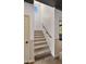 Carpeted staircase features natural light, offering an inviting transition to upper levels at 10224 E Talameer Ave, Mesa, AZ 85212