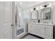 Bright bathroom features a double vanity with framed mirrors and a glass-enclosed shower with chevron tile flooring at 1057 W Laurel Ave, Gilbert, AZ 85233
