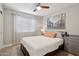 Bright bedroom with a ceiling fan, window, and artwork above the bed, creating a calming atmosphere at 1057 W Laurel Ave, Gilbert, AZ 85233