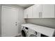 A convenient laundry room featuring modern appliances and ample storage cabinets for a clean and organized space at 1057 W Laurel Ave, Gilbert, AZ 85233