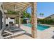 Relaxing covered patio area with stone pillars, ceiling fan, overlooking pool and backyard at 1057 W Laurel Ave, Gilbert, AZ 85233