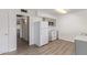 Cozy kitchen featuring laminate flooring, white appliances, and access to another room at 11149 W Palm Ridge Dr, Sun City, AZ 85351