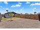 Gravel-covered backyard featuring wood fencing, with a partial view of the house and some green space at 1306 E Fillmore St, Phoenix, AZ 85006