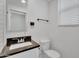 Modern bathroom featuring granite countertop, toilet, and a window with blinds at 1306 E Fillmore St, Phoenix, AZ 85006