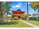 Charming two-story home featuring a vibrant red exterior, complemented by lush landscaping and a welcoming front yard at 1306 E Fillmore St, Phoenix, AZ 85006