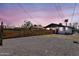 Charming home exterior with a wooden fence, desert landscaping, and a vibrant sunset backdrop at 1306 E Fillmore St, Phoenix, AZ 85006