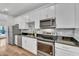 Kitchen with white cabinetry, stainless steel appliances, subway tile backsplash and modern fixtures at 1306 E Fillmore St, Phoenix, AZ 85006