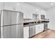Updated eat-in kitchen features white cabinetry, stainless steel appliances, and wood plank floors at 1306 E Fillmore St, Phoenix, AZ 85006
