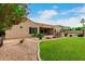 Well maintained backyard with lush lawn, desert landscaping, brick pavers, and views of the home's exterior at 13204 W Palo Verde Dr, Litchfield Park, AZ 85340