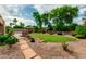 Beautiful backyard oasis with lush green grass, a covered gazebo, mature trees, and desert landscaping at 13204 W Palo Verde Dr, Litchfield Park, AZ 85340
