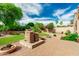 Lush backyard with a stone water fountain, mature trees, desert landscaping, and brick paved patio at 13204 W Palo Verde Dr, Litchfield Park, AZ 85340