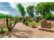 Lush backyard with an outdoor kitchen, mature trees, and a charming gazebo at 13204 W Palo Verde Dr, Litchfield Park, AZ 85340