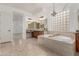 Bright bathroom featuring a soaking tub, dual vanity, granite countertops, and stylish mosaic tile flooring at 13204 W Palo Verde Dr, Litchfield Park, AZ 85340