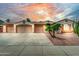 Inviting single-story home featuring a three-car garage and desert landscaping at sunset at 13204 W Palo Verde Dr, Litchfield Park, AZ 85340