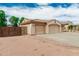 Side view of a home with a three-car garage and desert landscaping at 13204 W Palo Verde Dr, Litchfield Park, AZ 85340