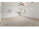 Bright living room with shutters, ceiling fan, and neutral carpet at 13204 W Palo Verde Dr, Litchfield Park, AZ 85340