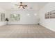 Spacious living room features a ceiling fan, neutral carpet, and bright natural light at 13204 W Palo Verde Dr, Litchfield Park, AZ 85340