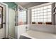 Bright bathroom with glass shower, bathtub, and a window featuring decorative glass blocks at 136 W Brahman Blvd, San Tan Valley, AZ 85143