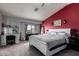Spacious main bedroom featuring modern furniture, a red accent wall and a ceiling fan at 136 W Brahman Blvd, San Tan Valley, AZ 85143