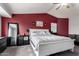 Comfortable main bedroom with a white bed frame, carpeted floors and red accent wall at 136 W Brahman Blvd, San Tan Valley, AZ 85143