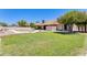 Spacious backyard featuring a pool, green lawn, and mature trees at 13650 N 70Th Dr, Peoria, AZ 85381