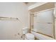 Bright bathroom featuring toilet and enclosed shower with a gold-trimmed sliding glass door at 13650 N 70Th Dr, Peoria, AZ 85381