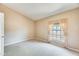 Bedroom with neutral carpet, curtains, and a large window allowing for ample natural light at 13650 N 70Th Dr, Peoria, AZ 85381