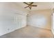 Bedroom with neutral carpet, neutral walls, a ceiling fan and a double door closet at 13650 N 70Th Dr, Peoria, AZ 85381