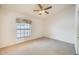 Bedroom with neutral walls, neutral carpet, large window with wood blinds and ceiling fan at 13650 N 70Th Dr, Peoria, AZ 85381