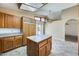 Open kitchen with custom cabinets, tile floors, island, skylight and stainless steel refrigerator at 13650 N 70Th Dr, Peoria, AZ 85381