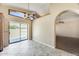 Kitchen nook with tile floors, archway to dining area, and sliding glass door leading to the patio at 13650 N 70Th Dr, Peoria, AZ 85381