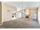Spacious living room with a fireplace, ceiling fan and an archway leading to the kitchen at 13650 N 70Th Dr, Peoria, AZ 85381