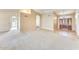 Open living room with carpeted floors, beige walls, and an archway leading to other rooms at 13650 N 70Th Dr, Peoria, AZ 85381