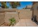 Enclosed back patio with neutral colored walls, a wooden gate, small trees and low maintenance desert landscaping at 1506 N Oak St, Tempe, AZ 85288