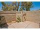 Enclosed back patio featuring neutral colored walls, a wooden gate, small trees and low maintenance desert landscaping at 1506 N Oak St, Tempe, AZ 85288