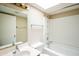 Bright bathroom featuring a skylight, vanity, toilet, and a shower-tub combination with white tiling at 1506 N Oak St, Tempe, AZ 85288