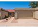 Beige home featuring a red tile roof, a front entrance gate, desert landscaping and an attached beige garage at 1506 N Oak St, Tempe, AZ 85288