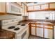 Updated kitchen showcasing white appliances and wood-trimmed cabinets, with view into living area at 1506 N Oak St, Tempe, AZ 85288