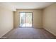 Living room with sliding glass doors to backyard, neutral walls, and carpet at 1506 N Oak St, Tempe, AZ 85288