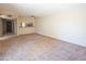 Living room with neutral walls and carpet, and adjacent kitchen visible in background at 1506 N Oak St, Tempe, AZ 85288