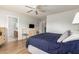 Bright bedroom featuring wood floors, a ceiling fan, and an adjacent bathroom at 16031 W Williams St, Goodyear, AZ 85338