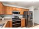 Modern kitchen with stainless steel appliances, wooden cabinets, and an electric range at 16031 W Williams St, Goodyear, AZ 85338