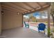 Covered patio with two plastic Adirondack chairs overlooking the backyard at 16031 W Williams St, Goodyear, AZ 85338