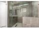 Modern tiled shower featuring multiple shower heads and stone floor at 16031 W Williams St, Goodyear, AZ 85338