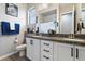 Well-lit bathroom featuring double sinks with granite countertops and white cabinets at 16226 S 35Th Dr, Phoenix, AZ 85045