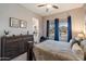 Bright bedroom with a dresser, a bed, and a view to the neighborhood through a sunny window at 16226 S 35Th Dr, Phoenix, AZ 85045