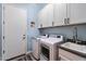 Convenient laundry room features ample storage cabinets, sink, washer, and dryer at 16226 S 35Th Dr, Phoenix, AZ 85045