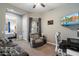 Comfortable living room with a gray couch, recliner, desk area, and a view into the bedroom at 16226 S 35Th Dr, Phoenix, AZ 85045
