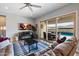 Cozy living room with a fireplace, ceiling fan, and sliding glass doors to the pool area at 16226 S 35Th Dr, Phoenix, AZ 85045