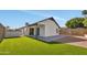 A spacious backyard with artificial grass, a covered patio, and a stone fence at 18205 N 18Th St, Phoenix, AZ 85022